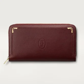 Billetera internacional con cremallera, Must De Cartier – Piel de becerro color burdeos, acabado dorado – Cartier