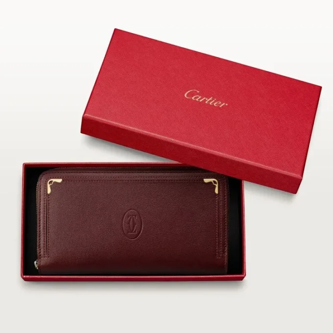 Billetera internacional con cremallera, Must De Cartier – Piel de becerro color burdeos, acabado dorado – Cartier Billetera internacional con cremallera, Must De Cartier – Piel de becerro color burdeos, acabado dorado – Cartier