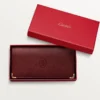 Billetera internacional con fuelles, Must de Cartier – Piel de becerro color burdeos, acabado dorado – Cartier Billetera internacional con fuelles, Must de Cartier – Piel de becerro color burdeos, acabado dorado – Cartier
