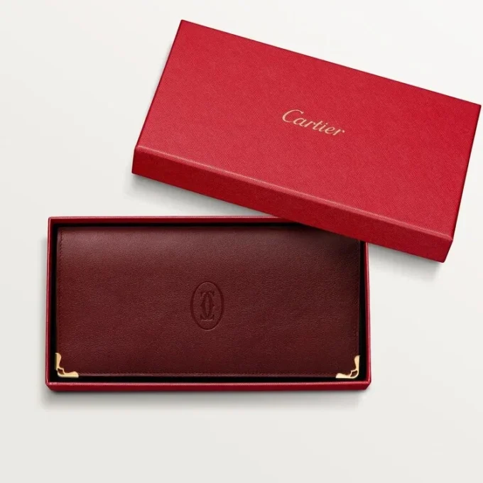 Billetera internacional con fuelles, Must de Cartier – Piel de becerro color burdeos, acabado dorado – Cartier Billetera internacional con fuelles, Must de Cartier – Piel de becerro color burdeos, acabado dorado – Cartier